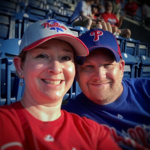 Jennifer and Chris smiling at a Phillies baseball game